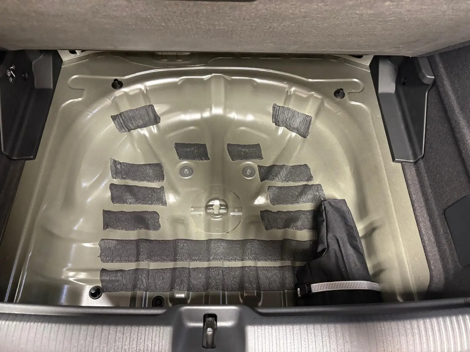 Logement de la roue de secours dans le coffre de l'Audi Q2 35 TFSI 150 S tronic 7 S line 2026, vue de dessus.