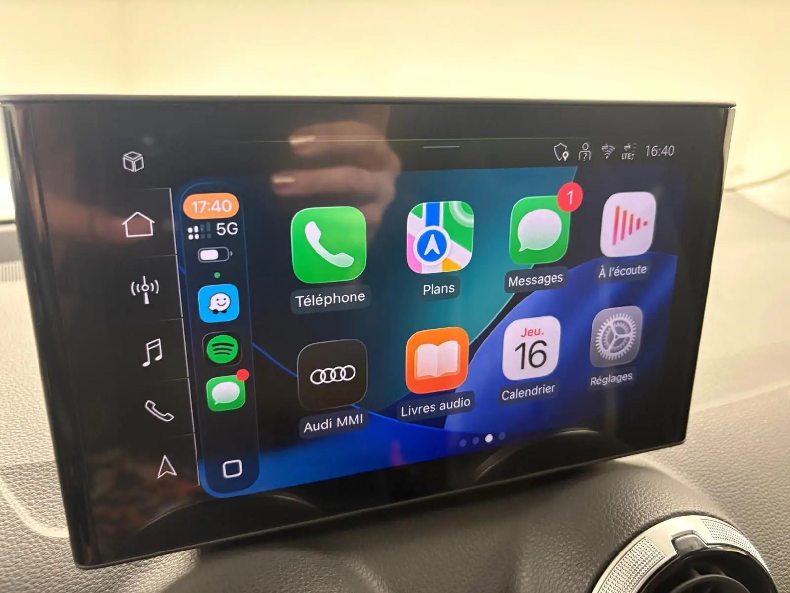 Écran tactile central de l'Audi Q2 35 TFSI 2026 affichant les applications connectées, avec tableau de bord noir en arrière-plan.