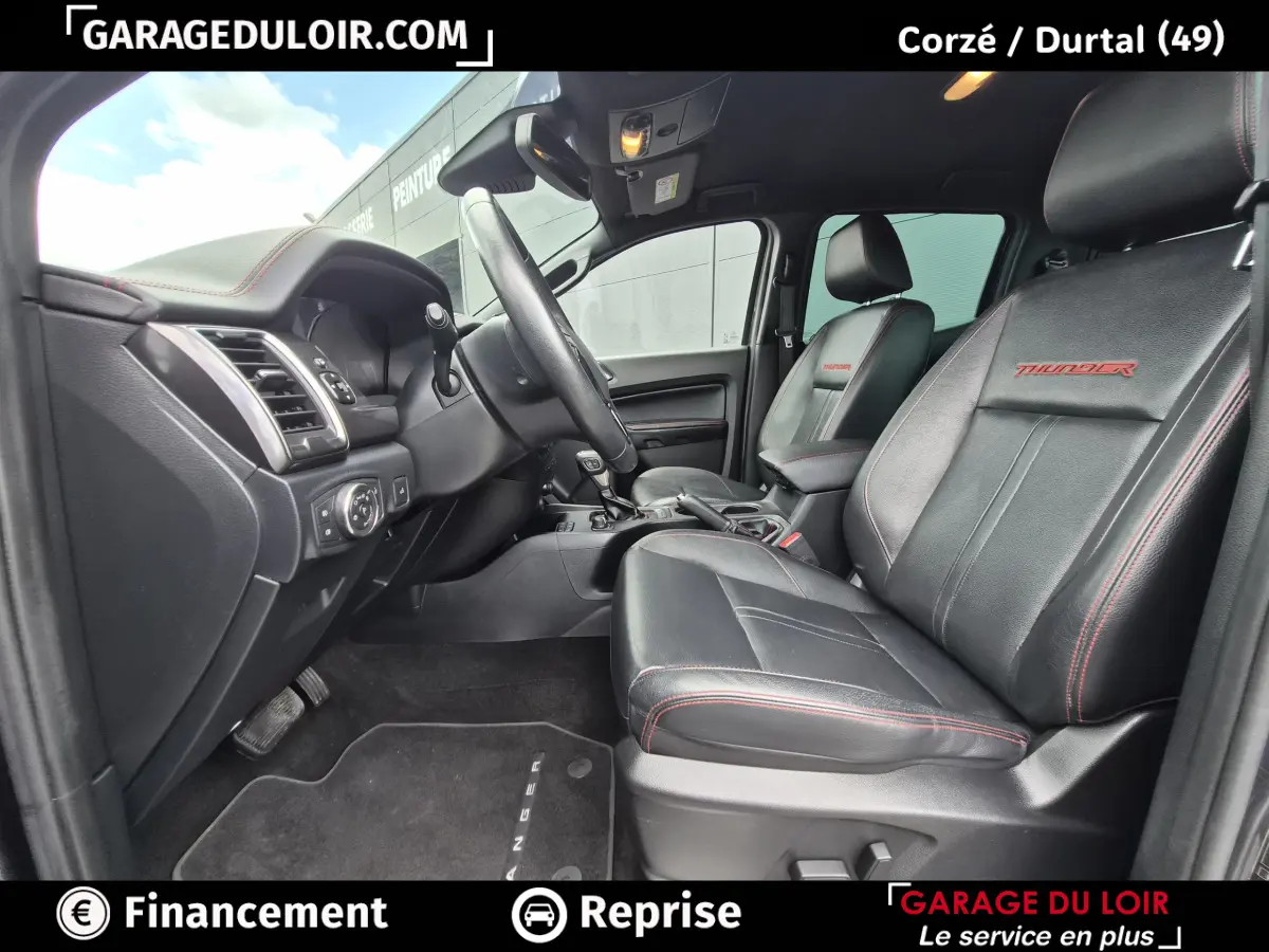 Vue intérieure côté conducteur du Ford Ranger Thunder 2020, sièges cuir noirs avec surpiqûres rouges et logo Thunder.