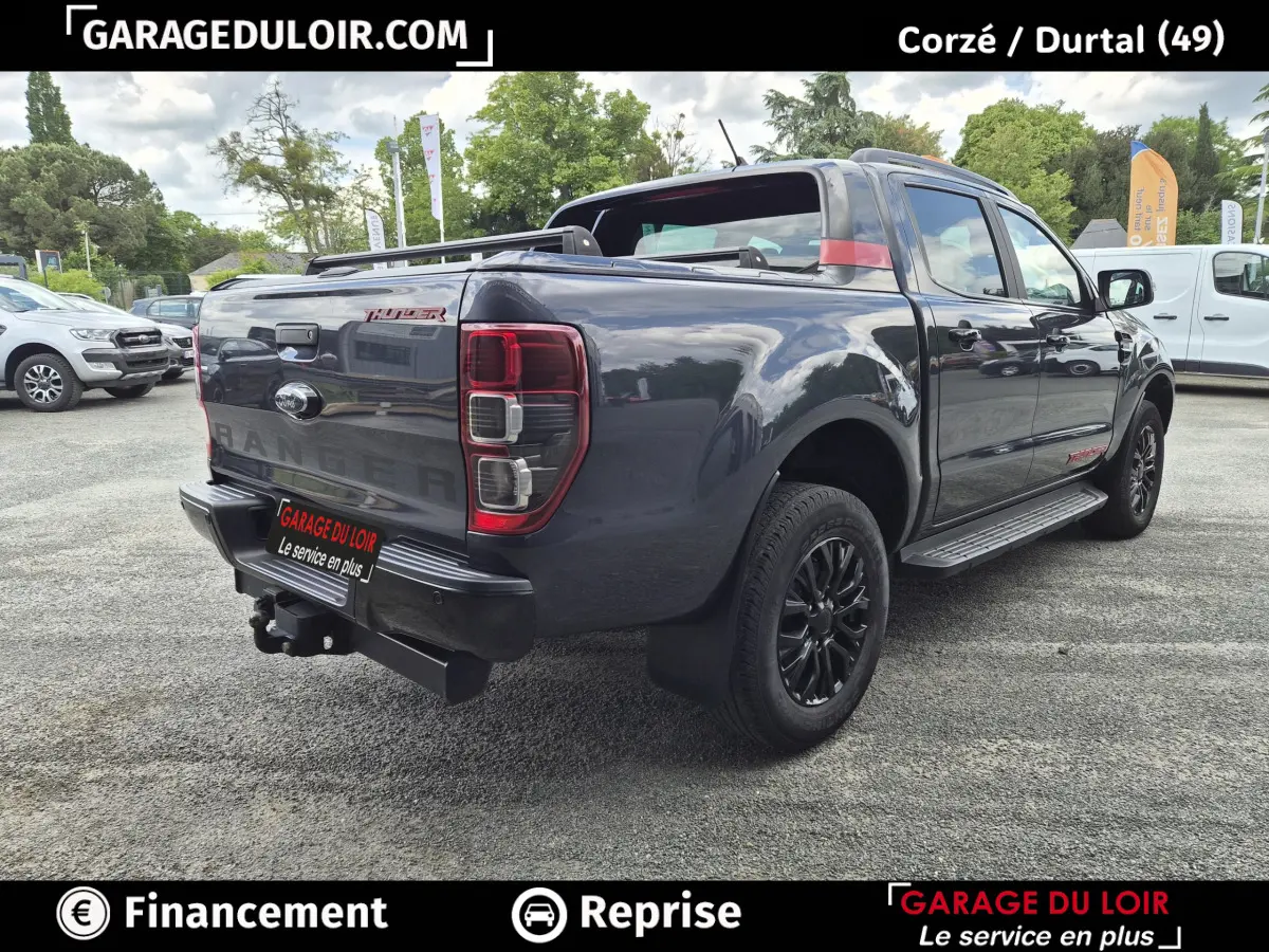 Ford Ranger Thunder gris foncé vu en 3/4 arrière droit, avec jantes noires et benne pick-up ouverte.