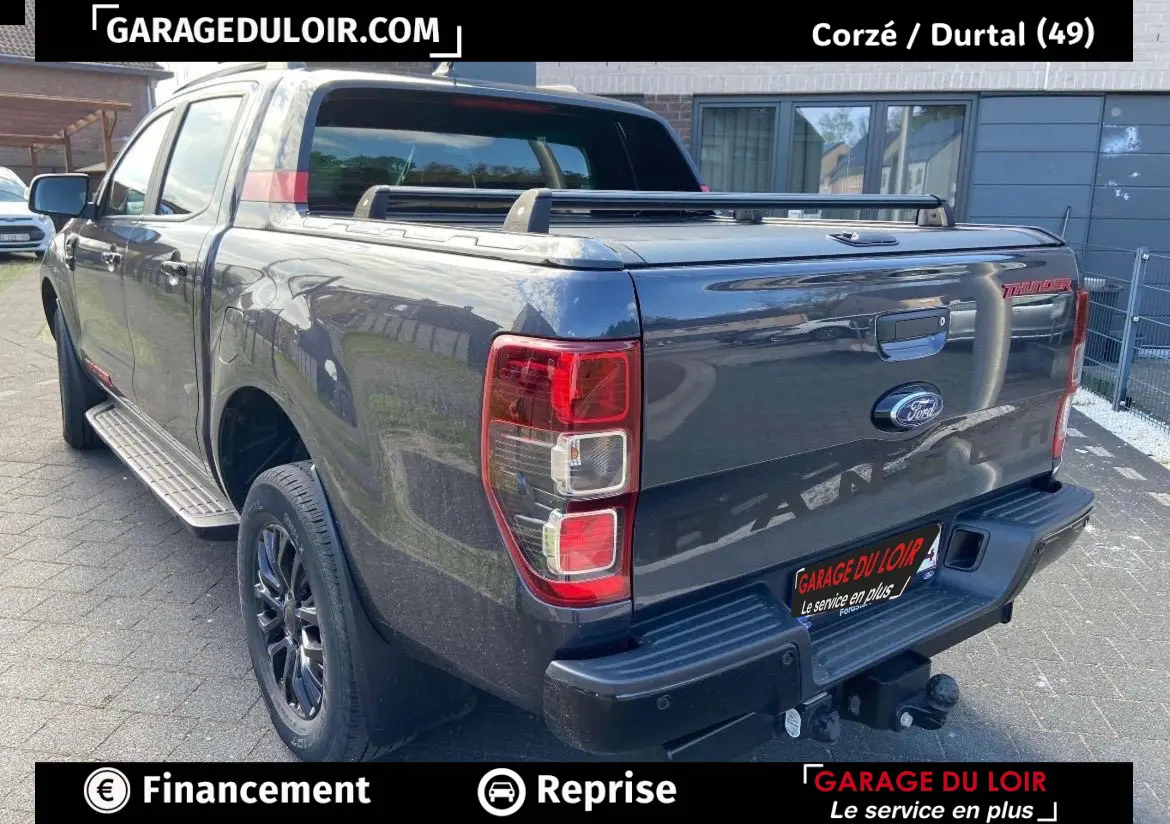 Vue 3/4 arrière droite d’un Ford Ranger Thunder gris foncé avec benne fermée et jantes noires.