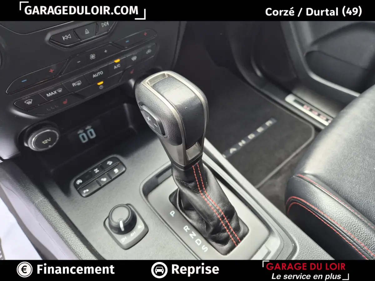 Gros plan sur la console centrale du Ford Ranger gris foncé, mettant en valeur le levier de vitesse automatique avec surpiqûres rouges.