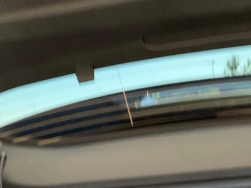 Vue arrière partielle du Citroën C5 Aircross noir Perla Nera avec lunette arrière teintée et toit visible en haut.