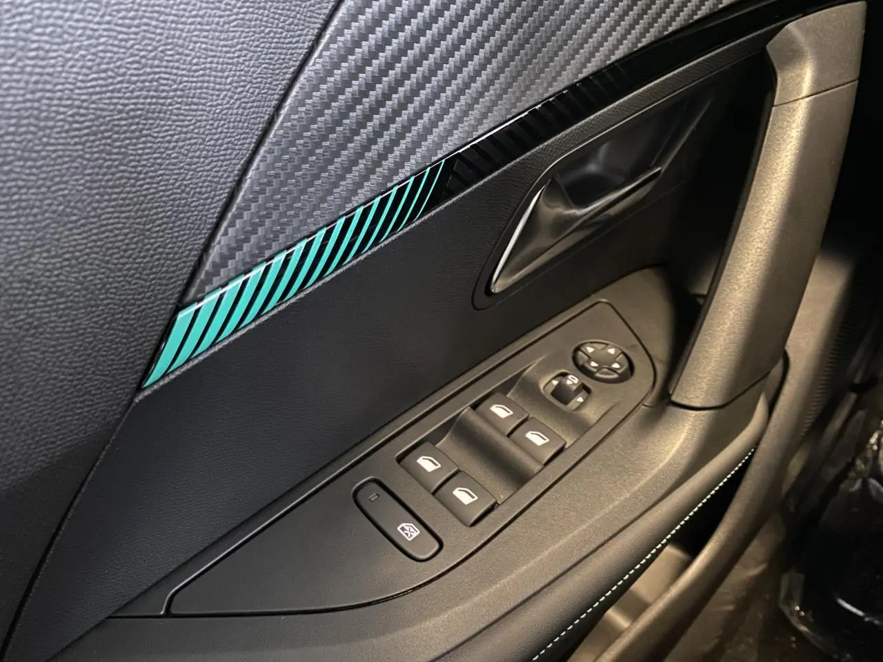 Détail de la porte côté gauche du Peugeot 2008 e-136 Allure Pack 2022 avec insert décoratif bleu et commandes de vitres électriques.