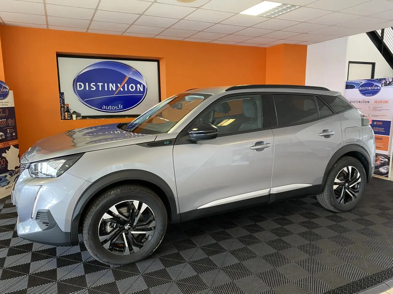 Peugeot 2008 e-136 Allure Pack gris Artense en vue profil droit, jantes alliage noires et toit noir en showroom.