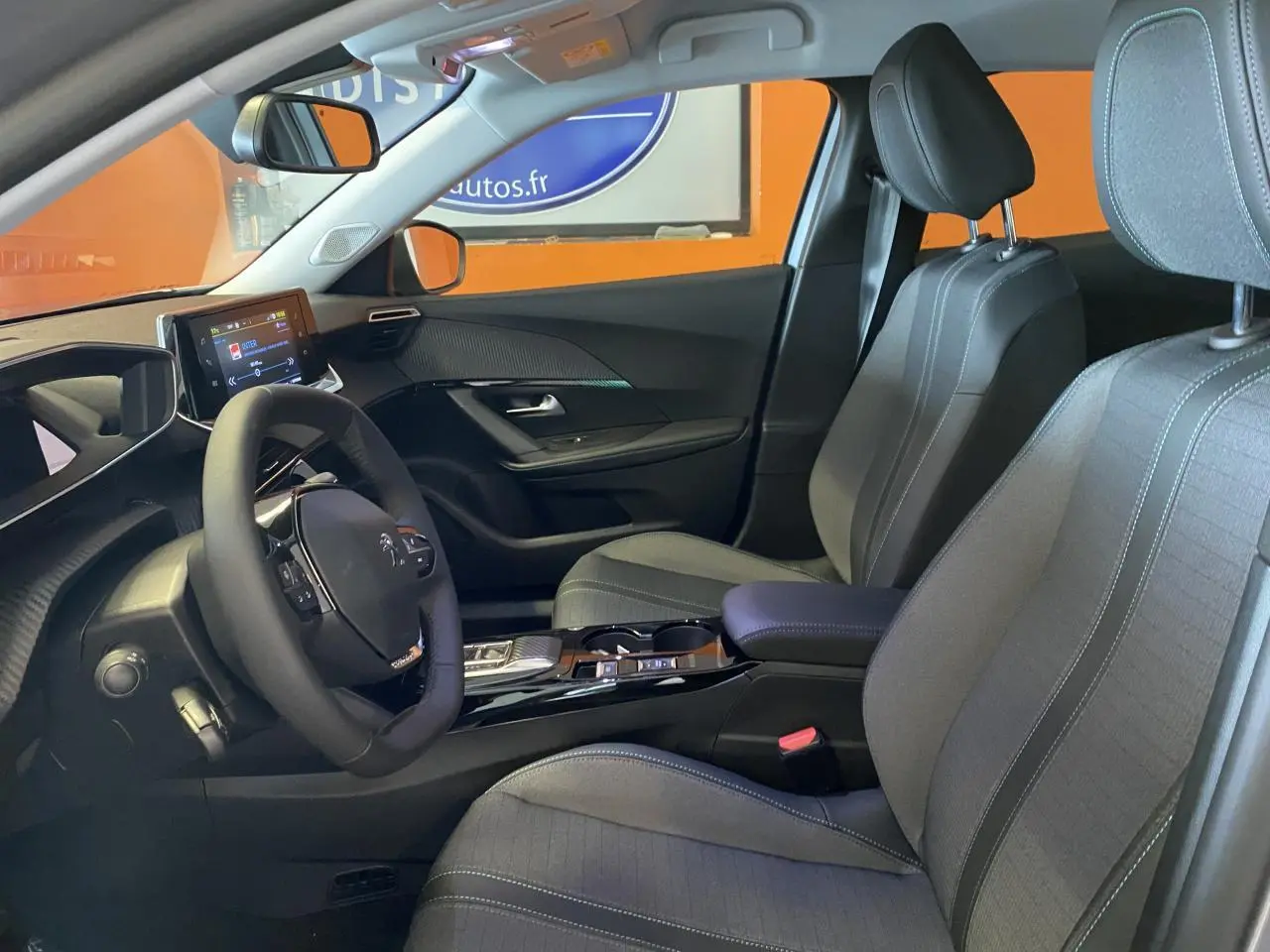 Intérieur avant du Peugeot 2008 e-136 Allure Pack 2022, sièges gris noir et tableau de bord avec écran tactile.