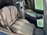 Intérieur avant du Peugeot 5008 bleu célèbes 2022, sièges TEP et tissu, accoudoirs centraux et volant multifonction cuir visible