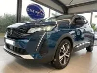 Vue 3/4 avant d'un Peugeot 5008 bleu célèbes 2022 avec calandre chromée et jantes alu en showroom.