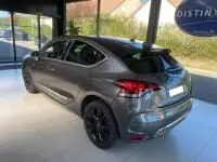 DS4 gris Platinium vue 3/4 arrière droit, jantes noires, feux LED et lignes dynamiques sous lumière intérieure.