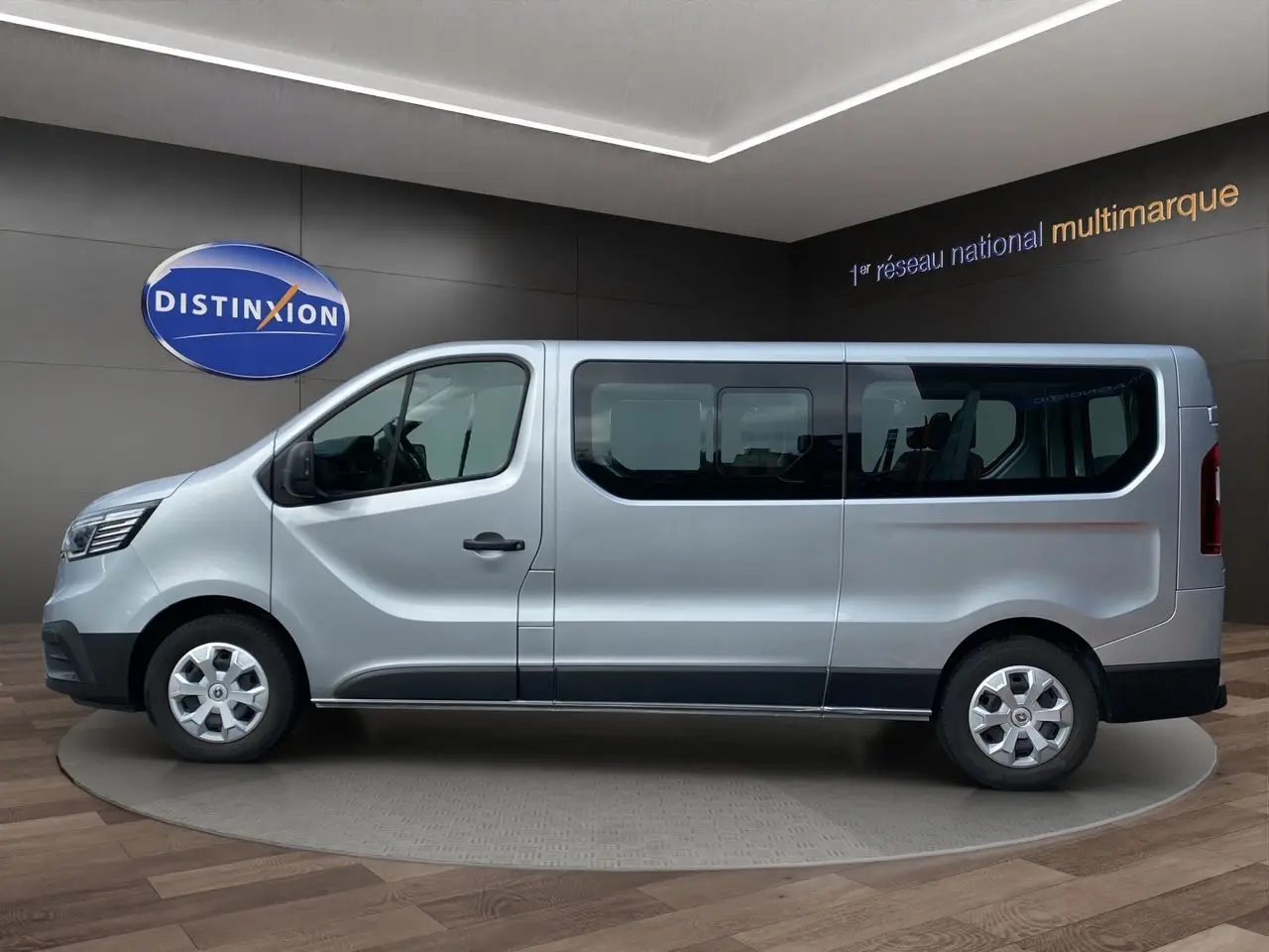Profil côté gauche d’un Renault Trafic Combi gris platine 2023, version 9 places, dans un showroom intérieur.