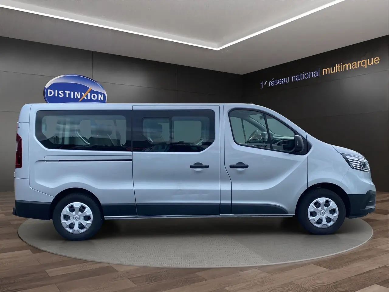 Vue de profil côté gauche d’un Renault Trafic Combi gris platine 2023, version 9 places avec vitres latérales teintées.