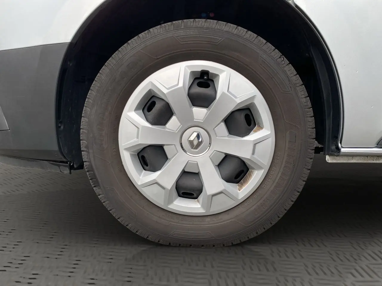 Gros plan sur la roue avant droite gris platine d’un Renault Trafic Combi 2023 avec jante en plastique et logo Renault central.