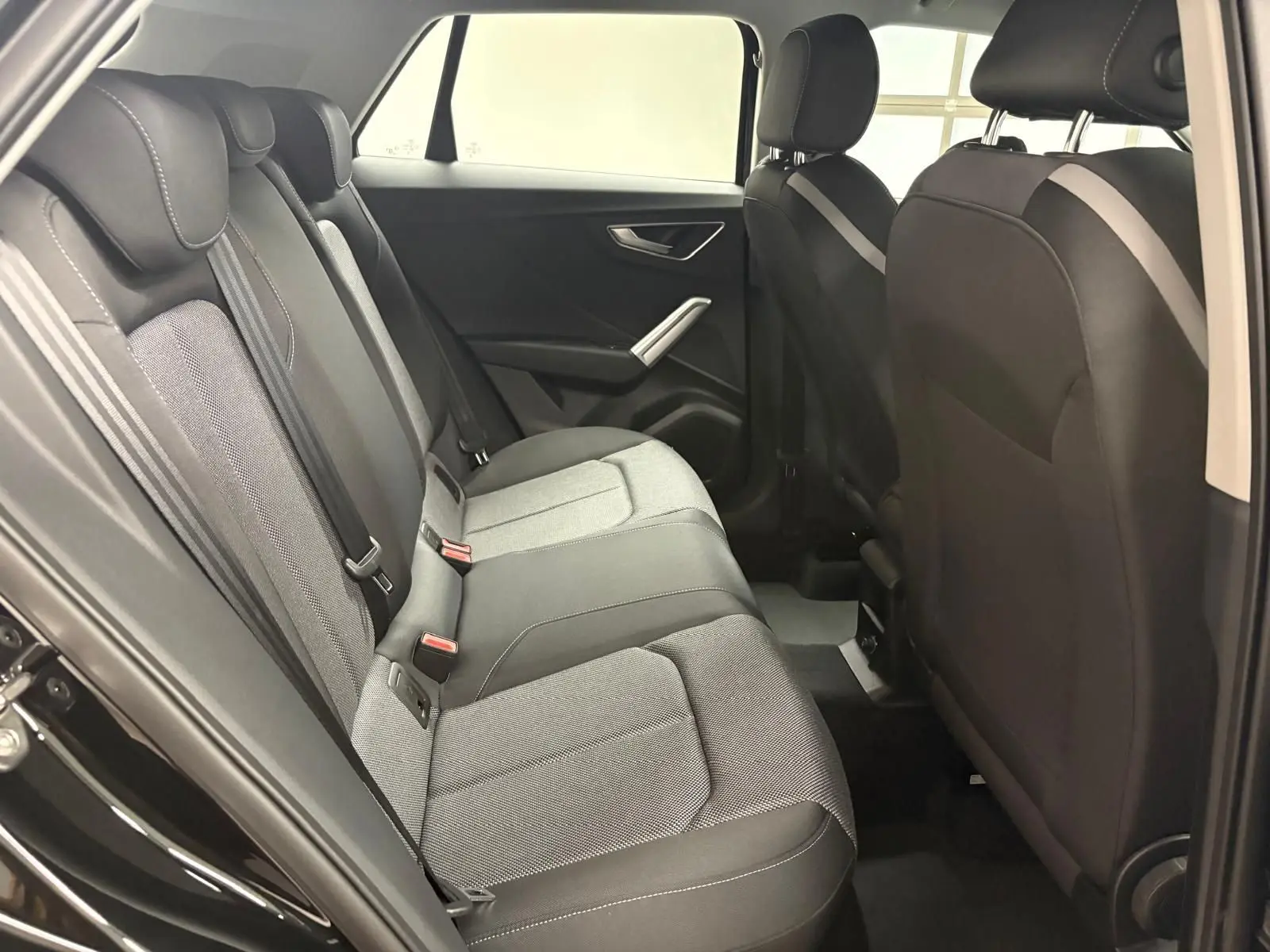 Vue intérieure côté droit des sièges arrière en tissu gris et noir de l’Audi Q2 35 TFSI S Line 2026.