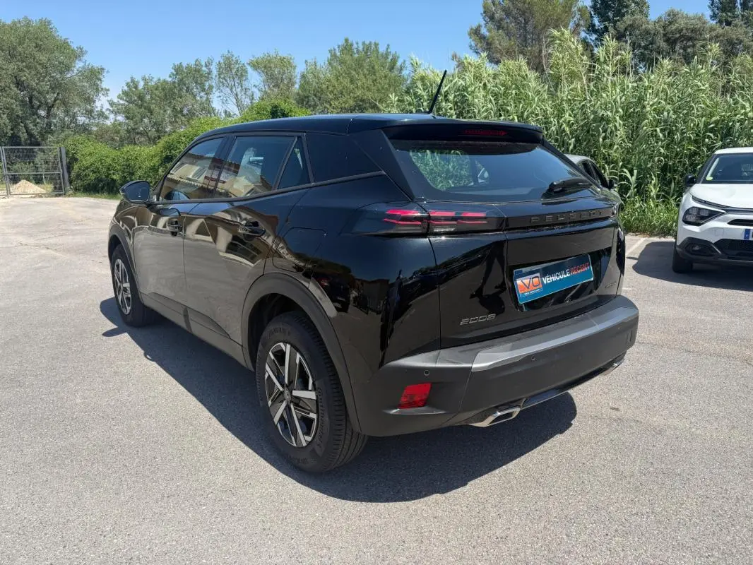 Peugeot 2008 Hybrid noir vue 3/4 arrière droit, jantes 16 pouces et feux arrière LED distinctifs.