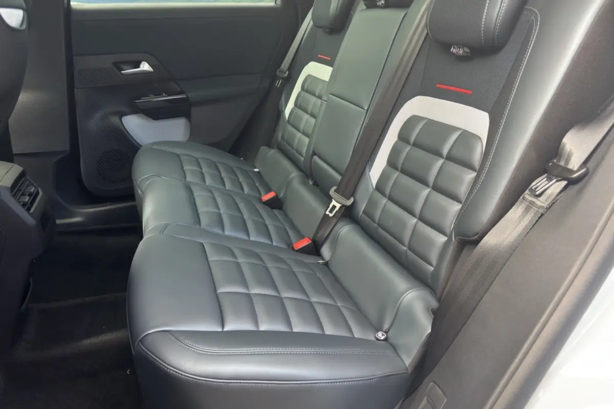 Vue latérale intérieure montrant la banquette arrière en cuir noir matelassé du Citroën C5 Aircross New Hybrid 2026.