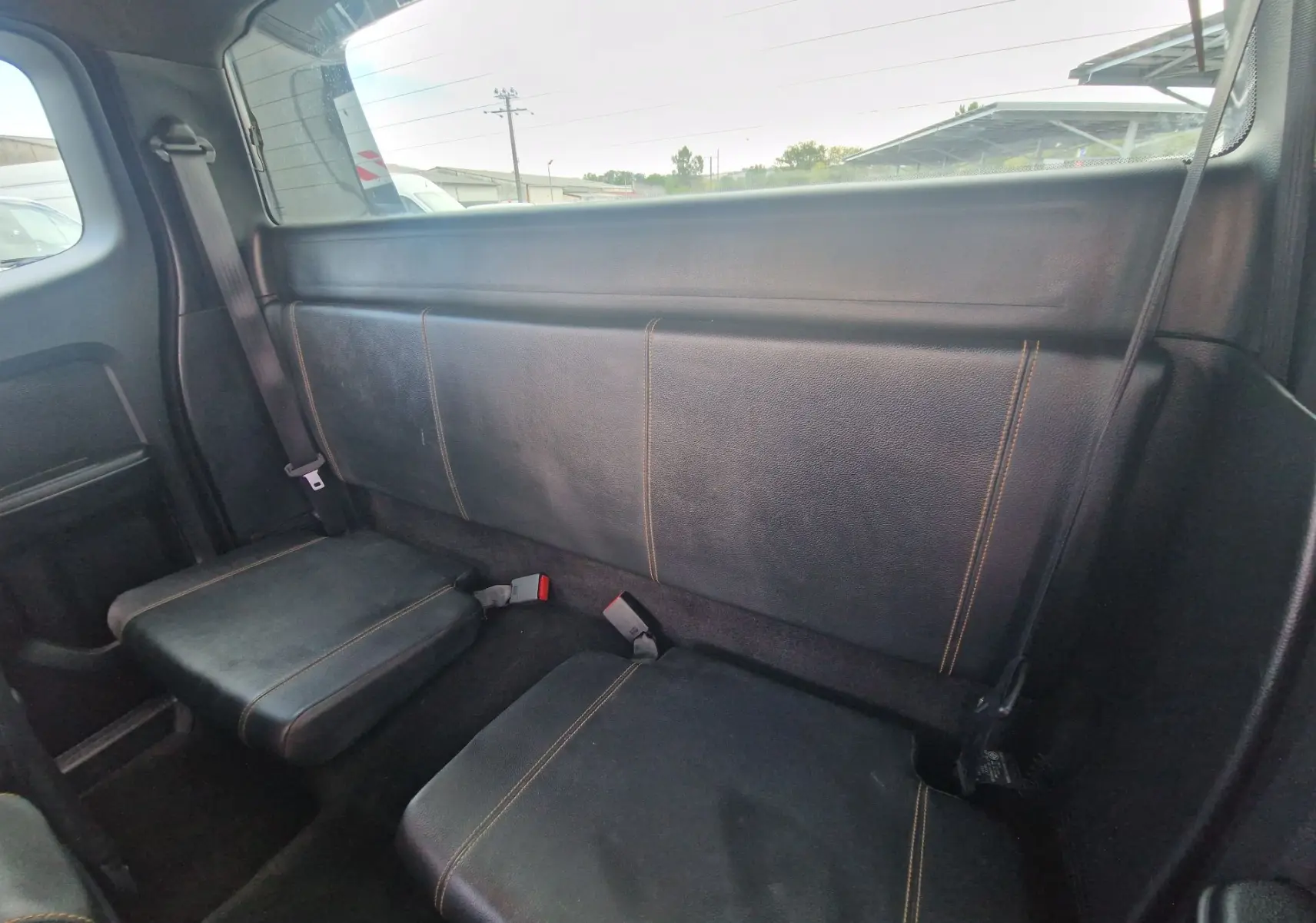 Vue intérieure arrière du Ford Ranger Super Cabine 2020, sièges noirs en cuir avec surpiqûres contrastantes.
