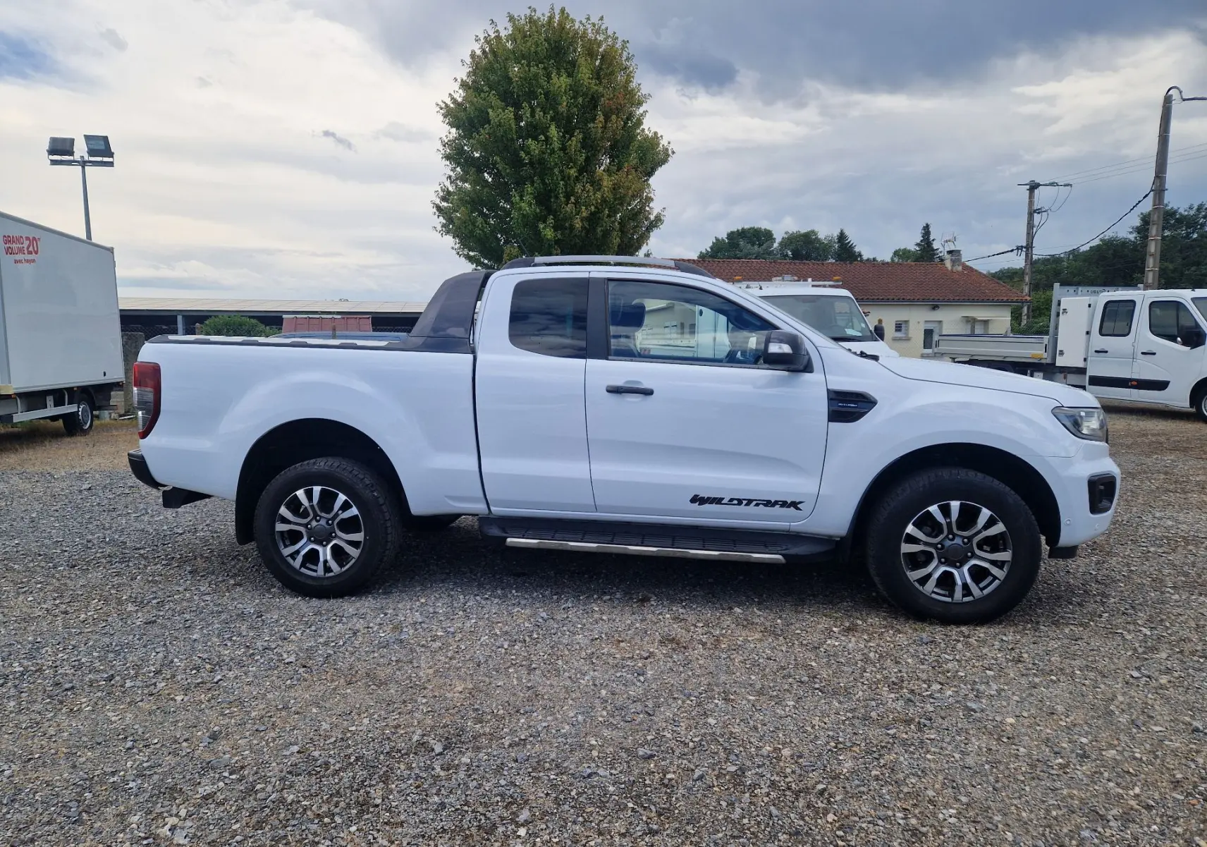 Ford Ranger Wildtrak blanc vu de profil côté gauche, avec cabine étendue et jantes alliage distinctives.