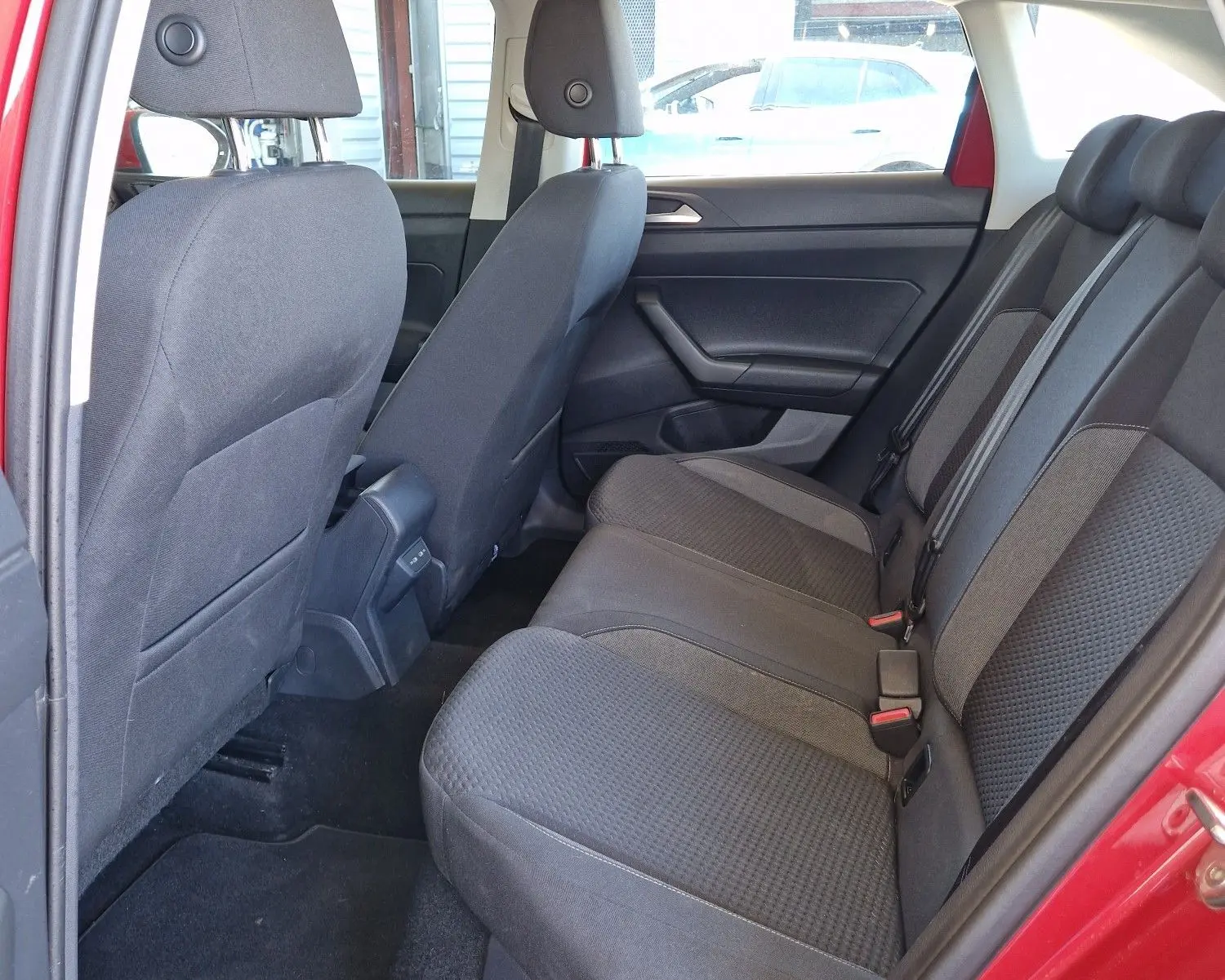 Vue intérieure côté gauche des sièges arrière noirs d'un Volkswagen Taigo rouge roi 2023, finition Life.