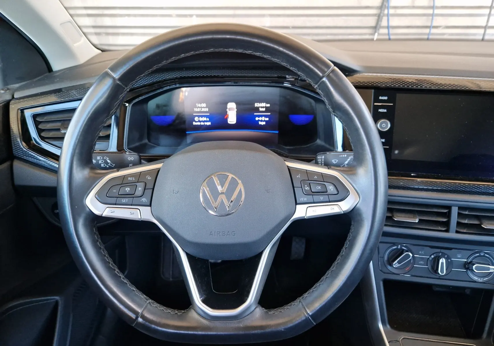 Volant cuir noir de Volkswagen Taigo 2023 avec commandes intégrées et tableau de bord digital lumineux.