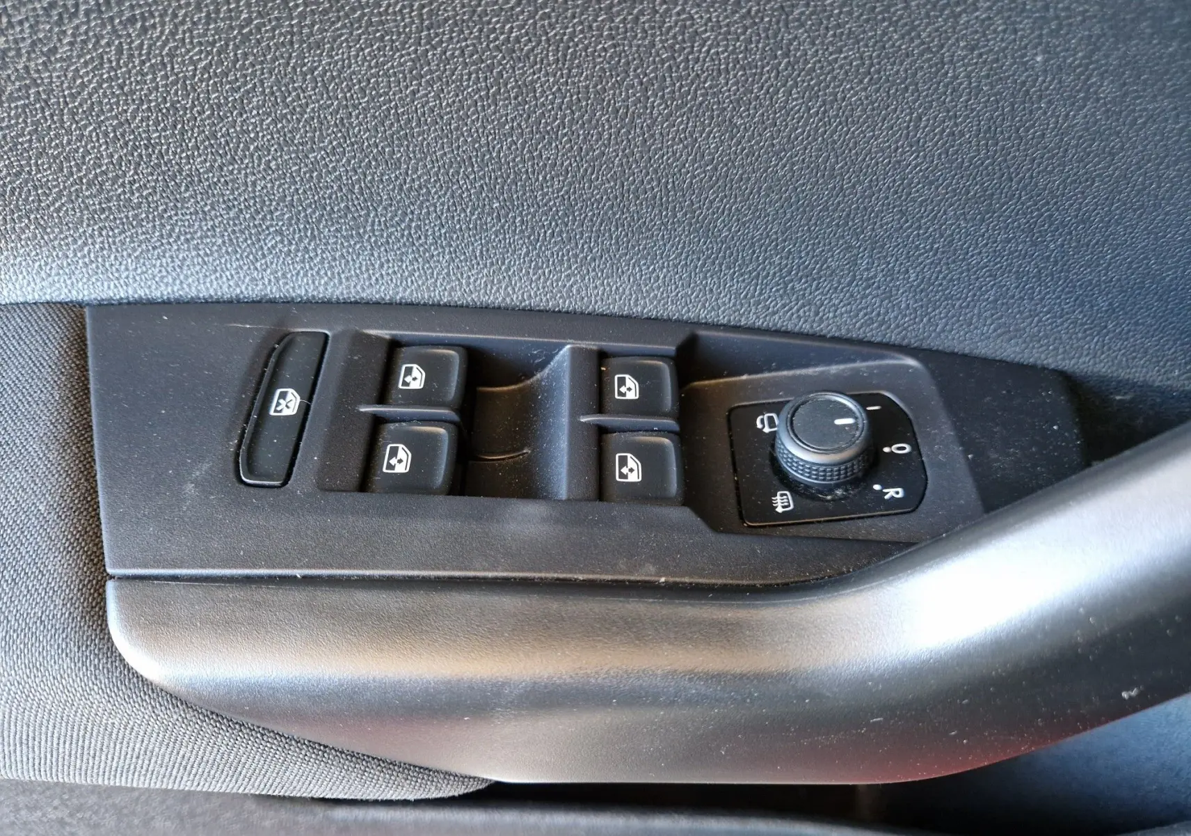 Commande des vitres électriques et réglage des rétroviseurs sur la portière côté gauche d'un Volkswagen Taigo rouge roi 2023.