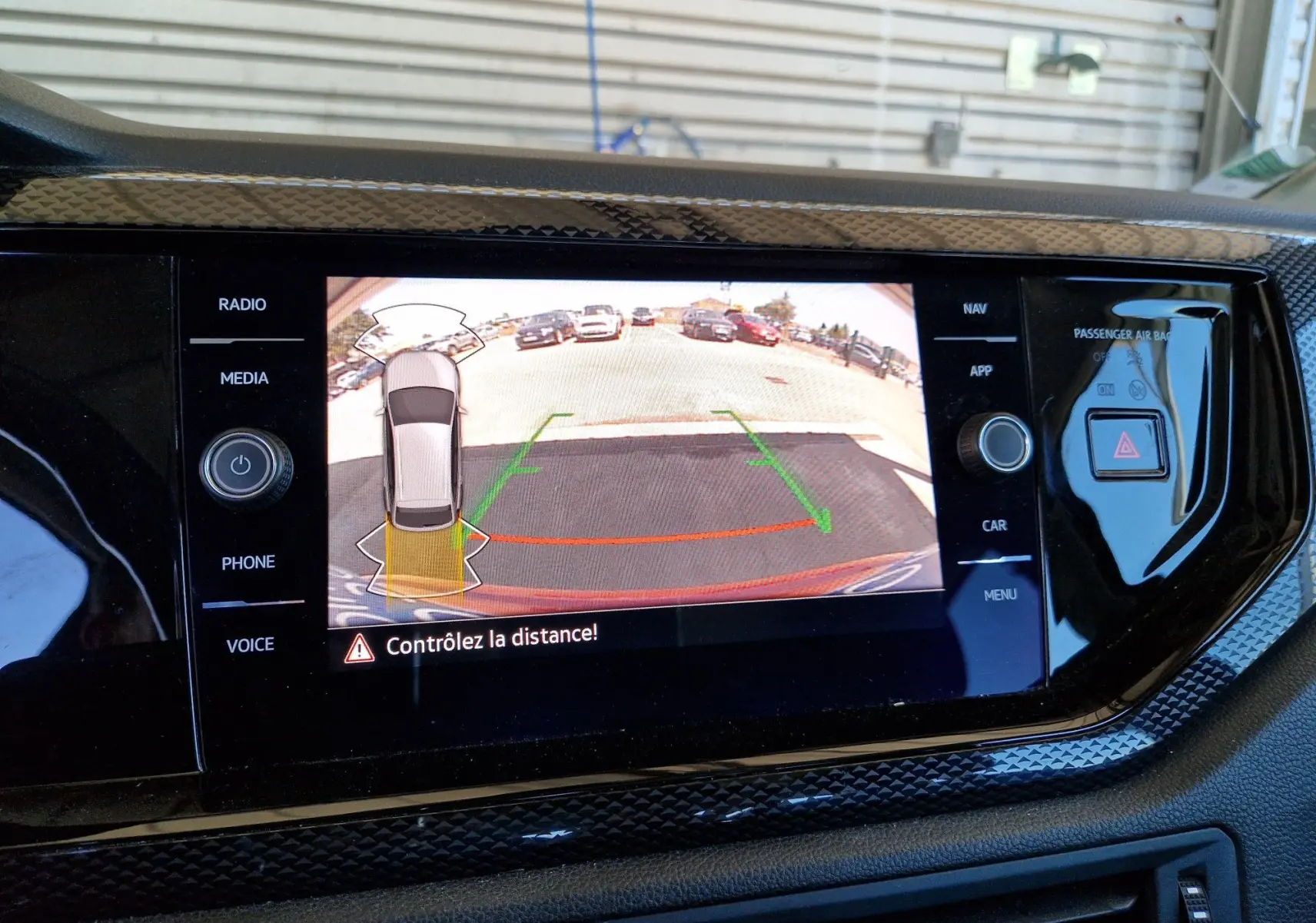 Écran central affichant la caméra de recul avec vue arrière et alertes de distance du Volkswagen Taigo rouge roi 2023.