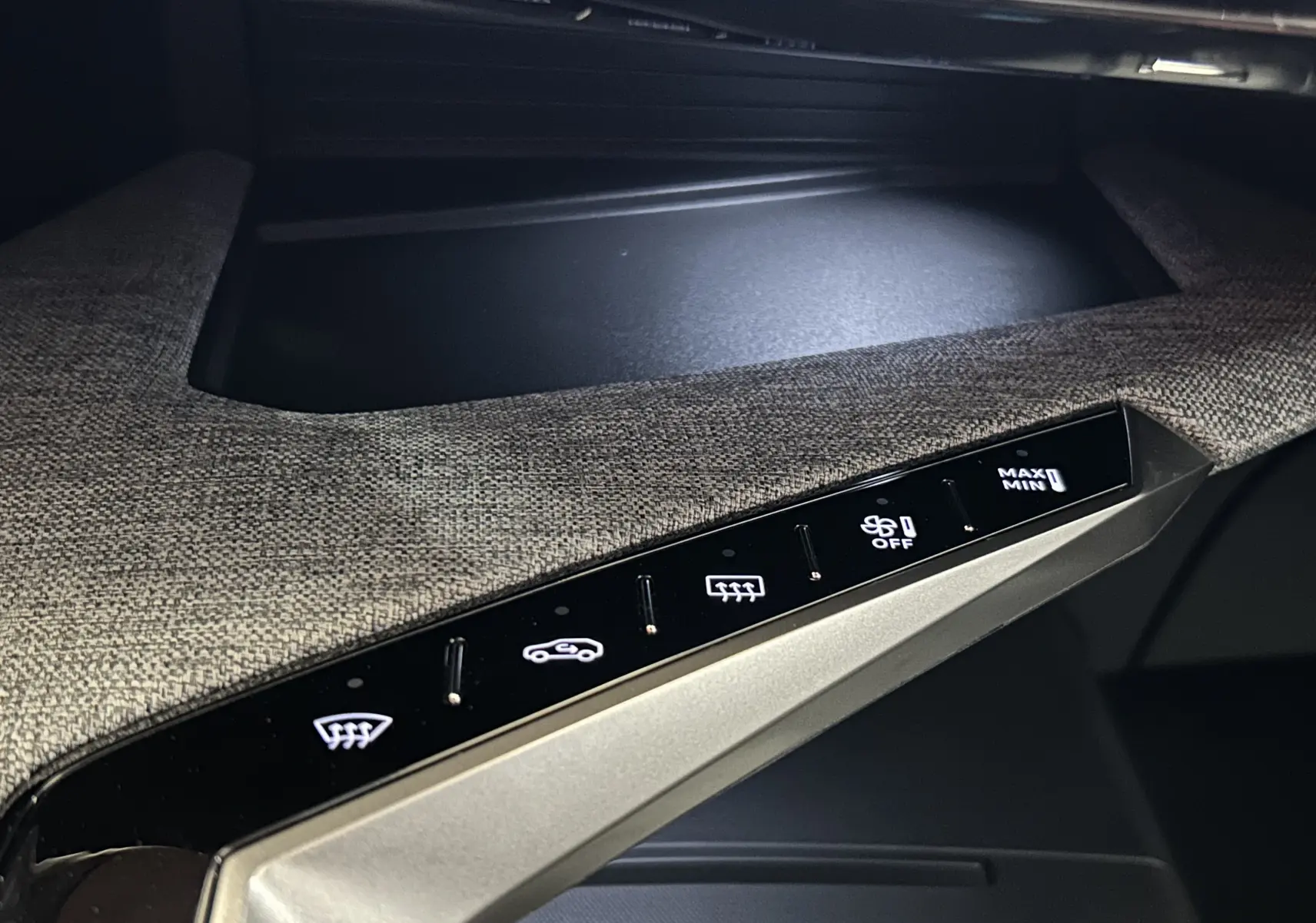 Gros plan sur la console centrale du Peugeot 5008 III Hybrid 145 GT, montrant les commandes tactiles sur tissu gris.