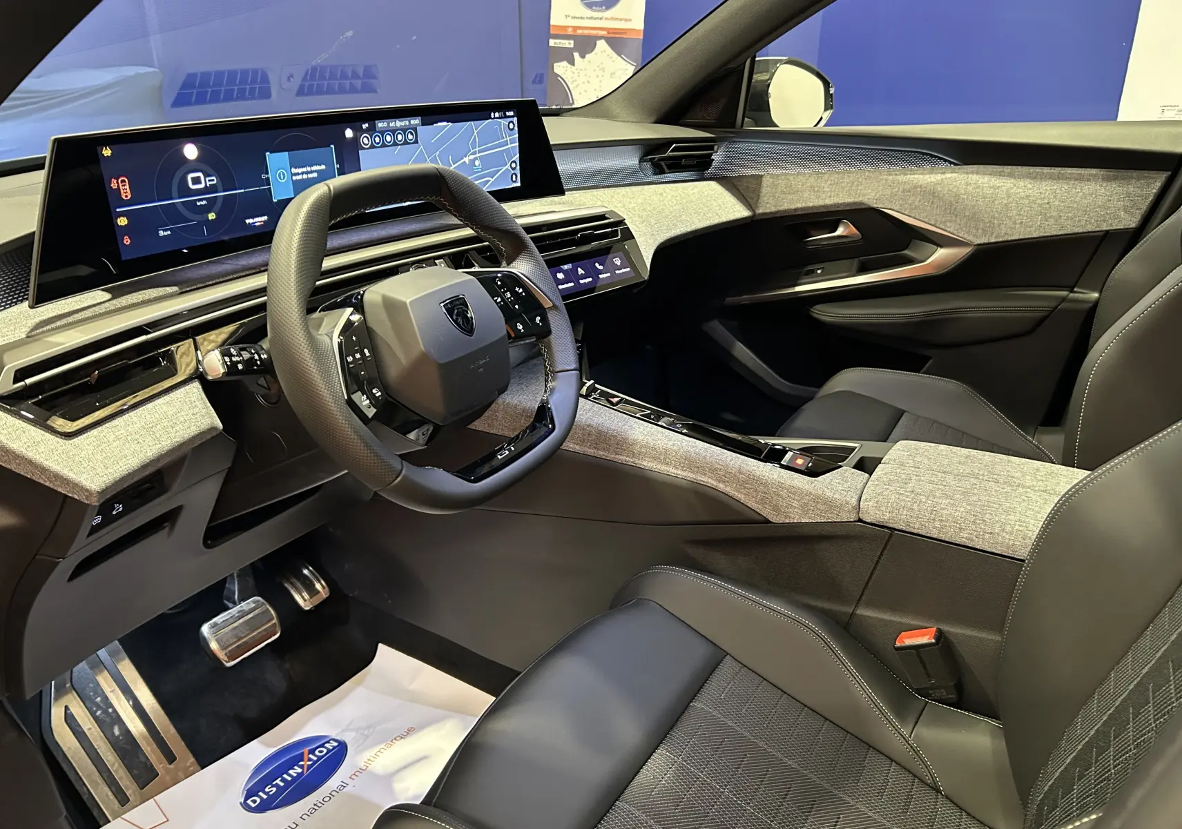 Intérieur avant droit du Peugeot 5008 Hybrid 2026 avec tableau de bord numérique et sellerie cuir gris.