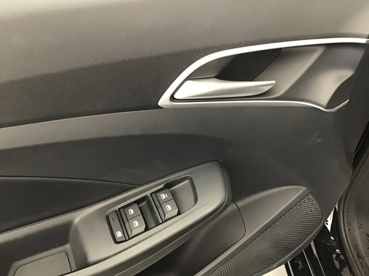 Détail de la porte côté conducteur du MG3 1.5 Hybrid+ Pebble Black, avec commandes de vitres et poignée argentée.