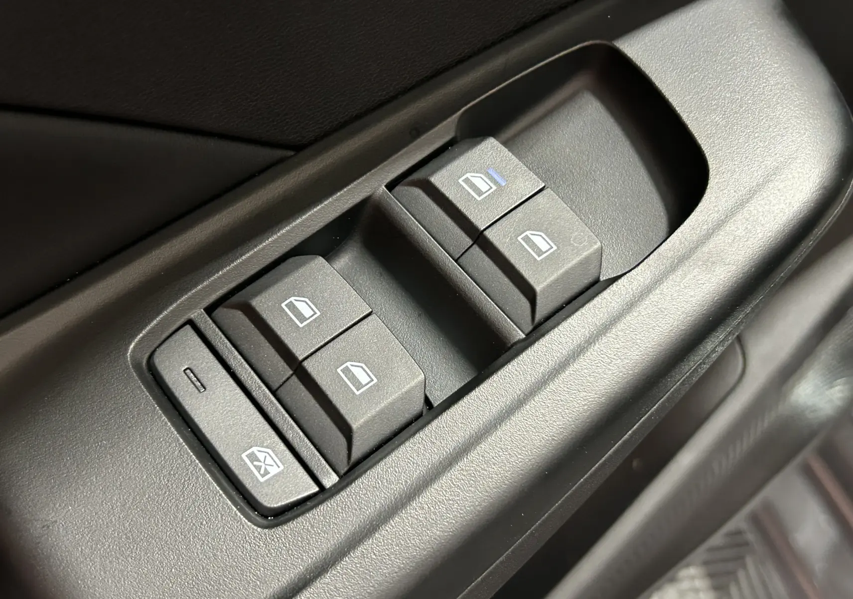 Gros plan sur les commandes de lève-vitres électriques côté conducteur de la MG3 Pebble Black 2026.