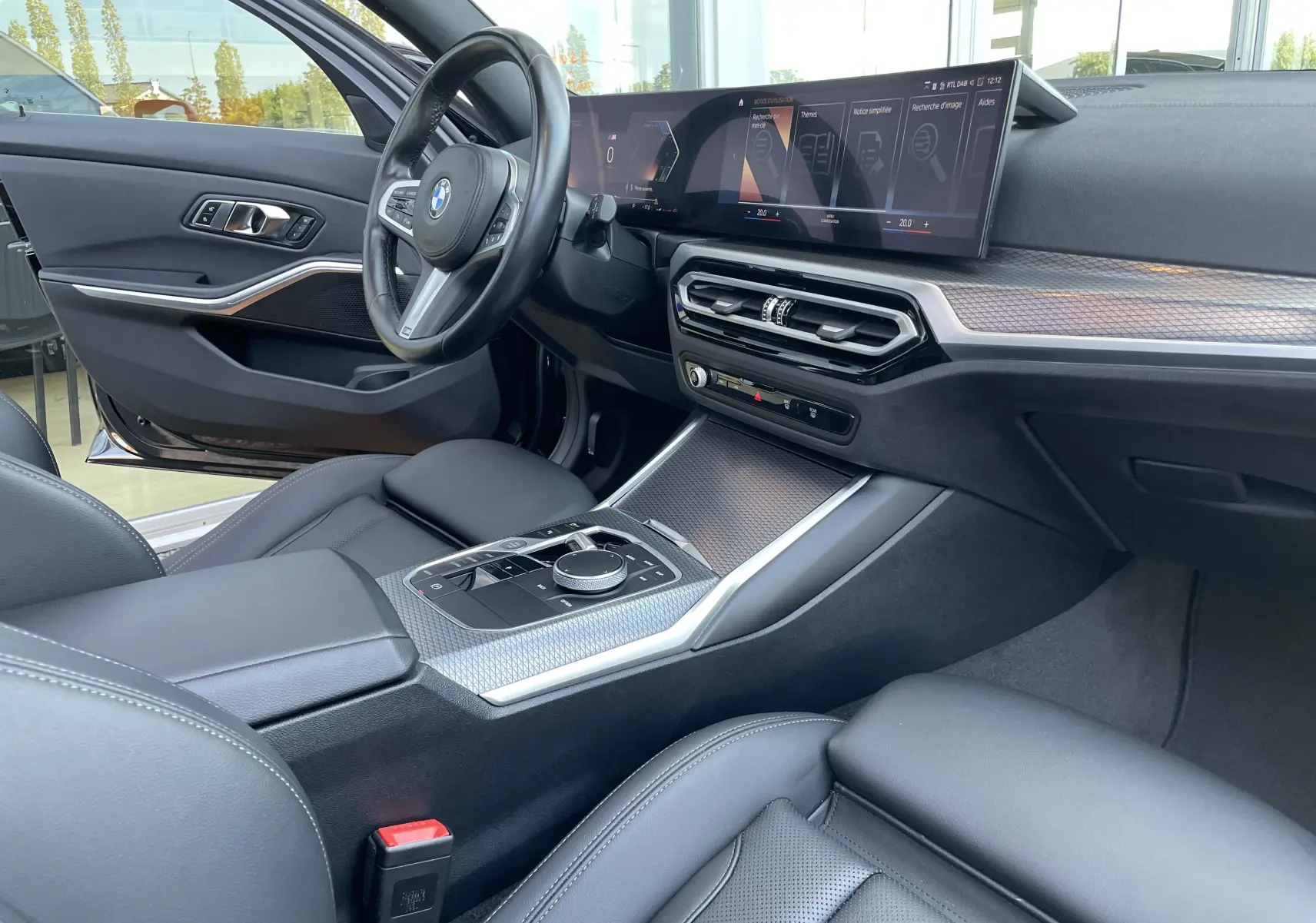 Intérieur noir cuir de la BMW Série 3 Touring G21 xDrive 190 M Sport, vue côté conducteur avec tableau de bord numérique et console centrale moderne.
