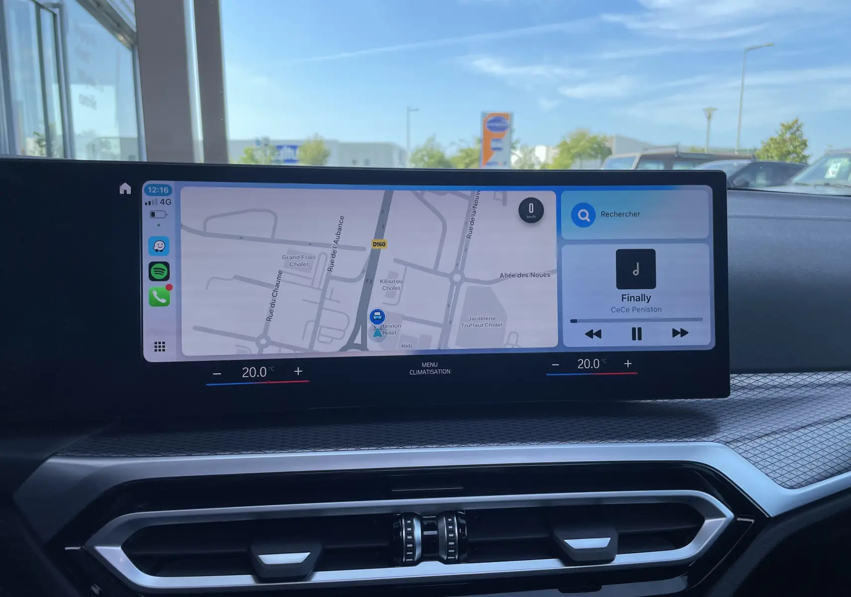 Écran tactile central affichant la navigation et la musique dans l'habitacle gris-noir d'une BMW Série 3 Touring G21 2022.