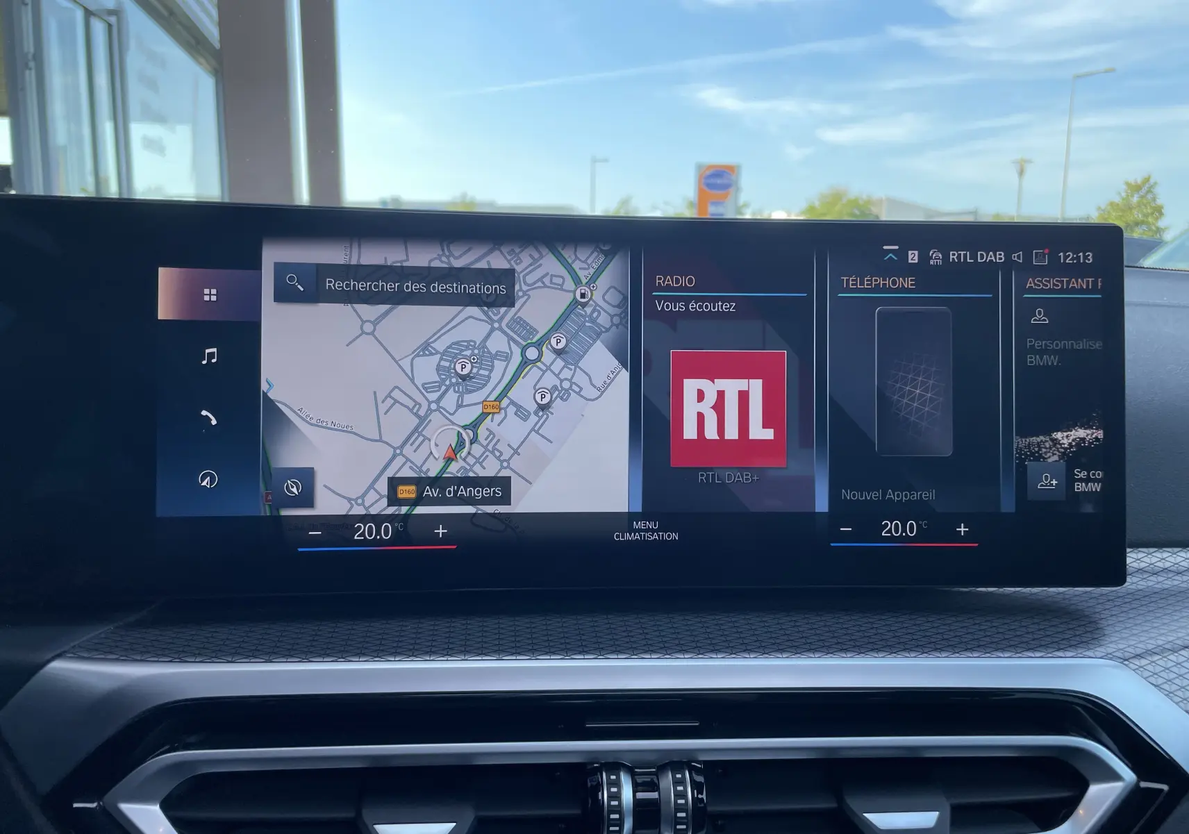 Écran central tactile de la BMW Série 3 Touring G21 noir métal 2022 affichant navigation, radio RTL et téléphone.