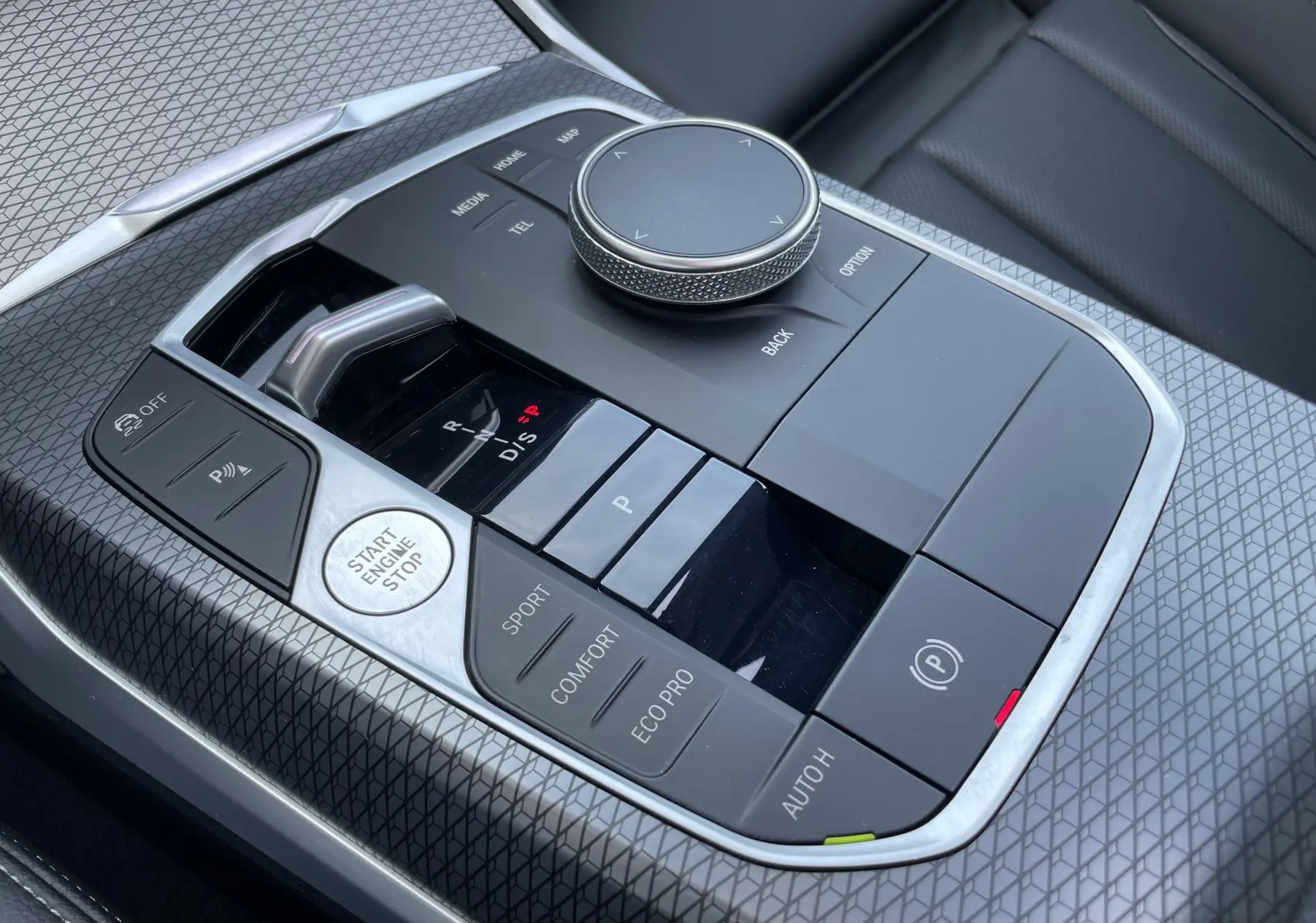 Gros plan sur la console centrale noire de la BMW Série 3 Touring G21 XDrive 190 M Sport avec commandes de boîte auto et modes de conduite.