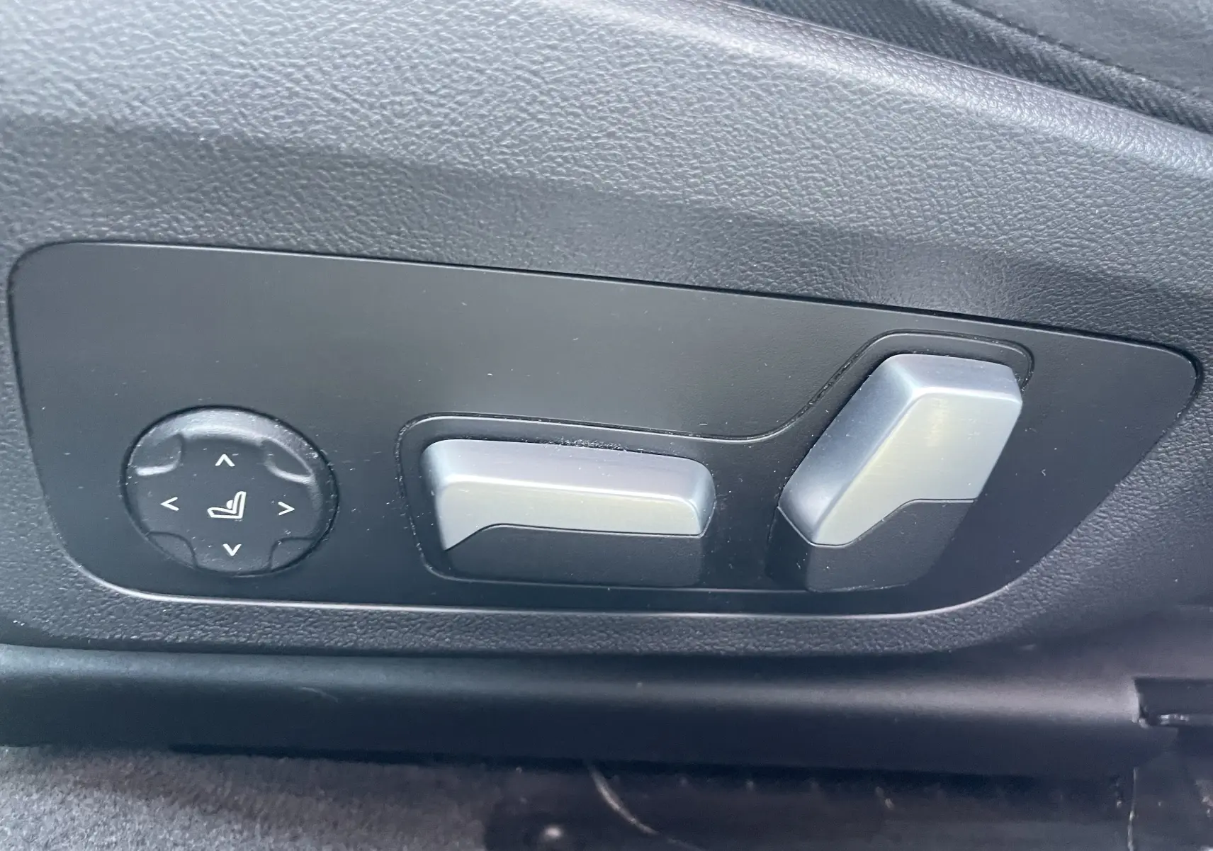 Commandes électriques de réglage du siège côté gauche dans une BMW Série 3 Touring G21 noire, version M Sport 2022.