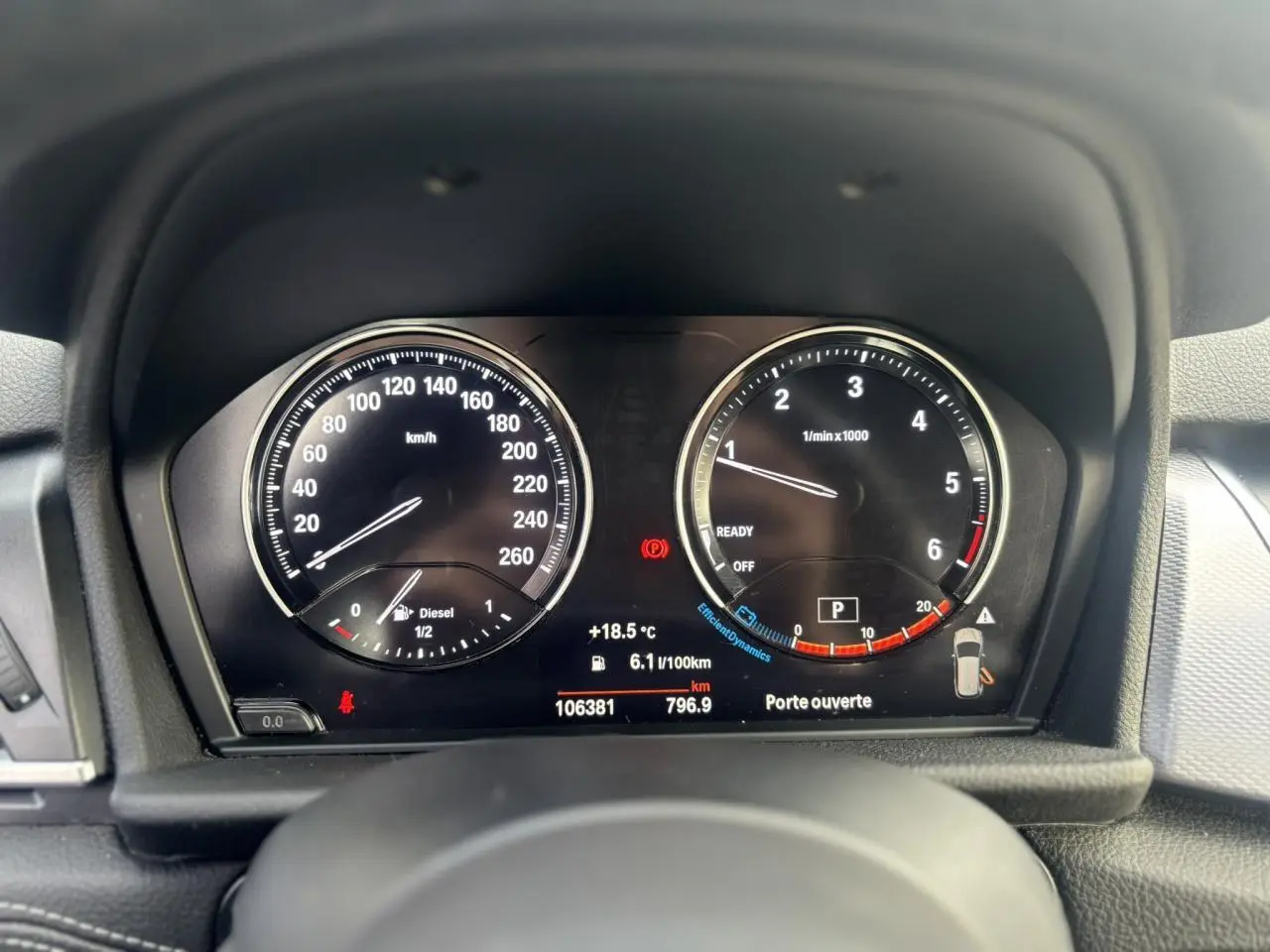 Vue rapprochée du tableau de bord de la BMW Série 2 Active Tourer blanc, affichant compteurs et informations numériques.