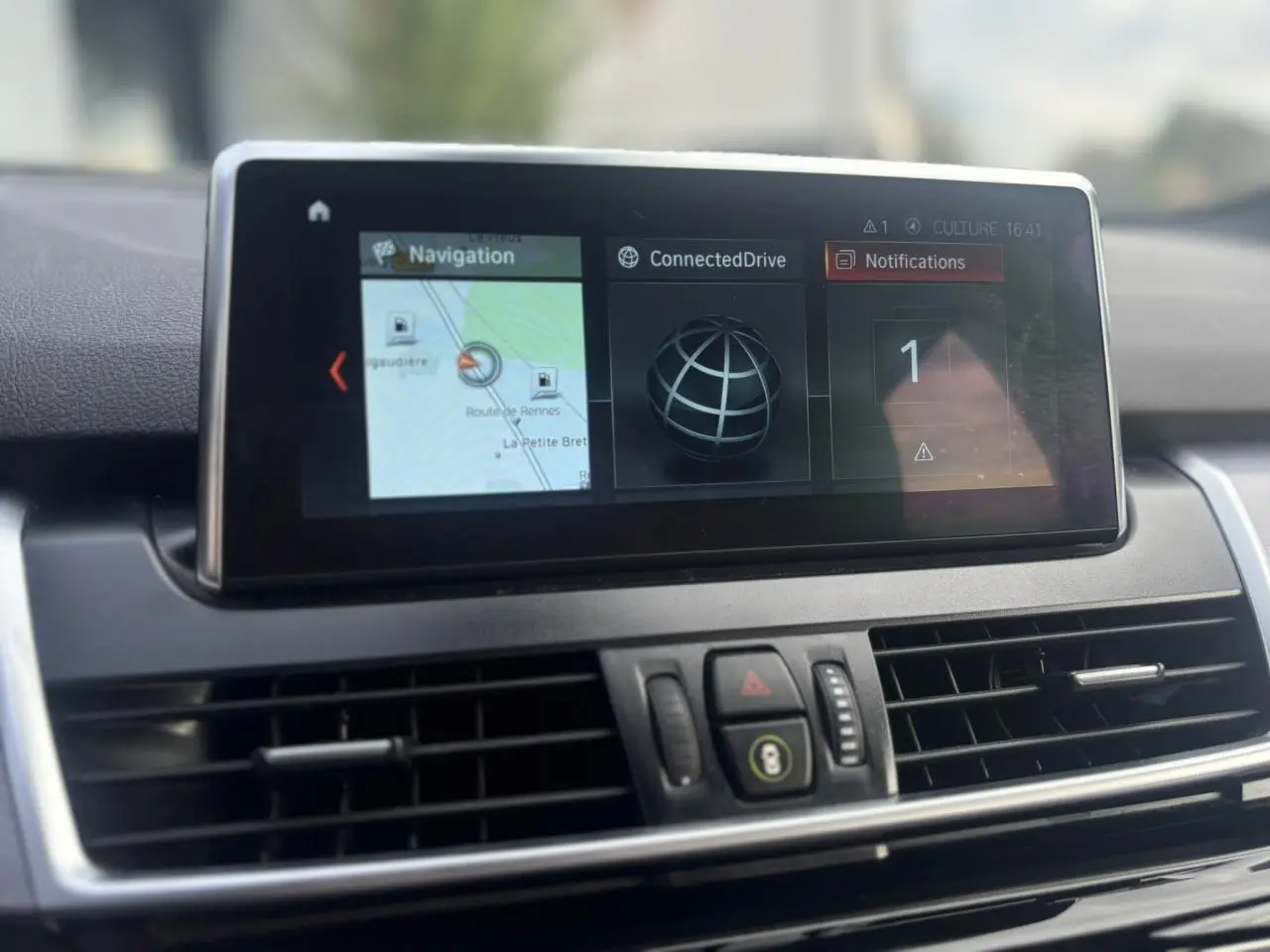 Écran central du GPS de la BMW Série 2 Active Tourer 218dA blanc, affichant la navigation et notifications.
