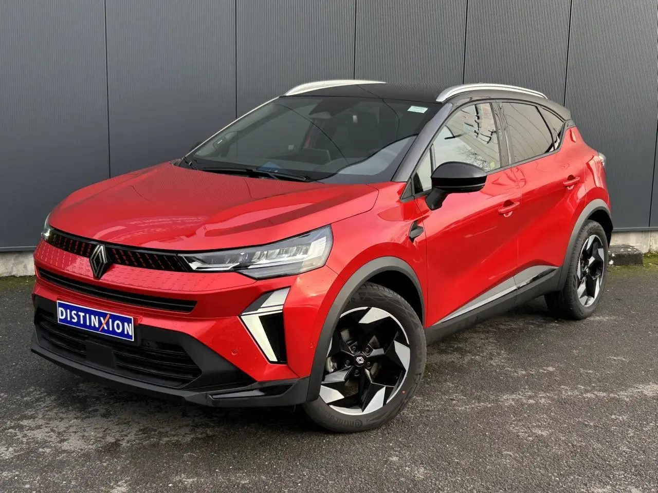 Renault Captur 2025 rouge Flamme et noir, vue 3/4 avant droit avec jantes alu noires et toit alu.