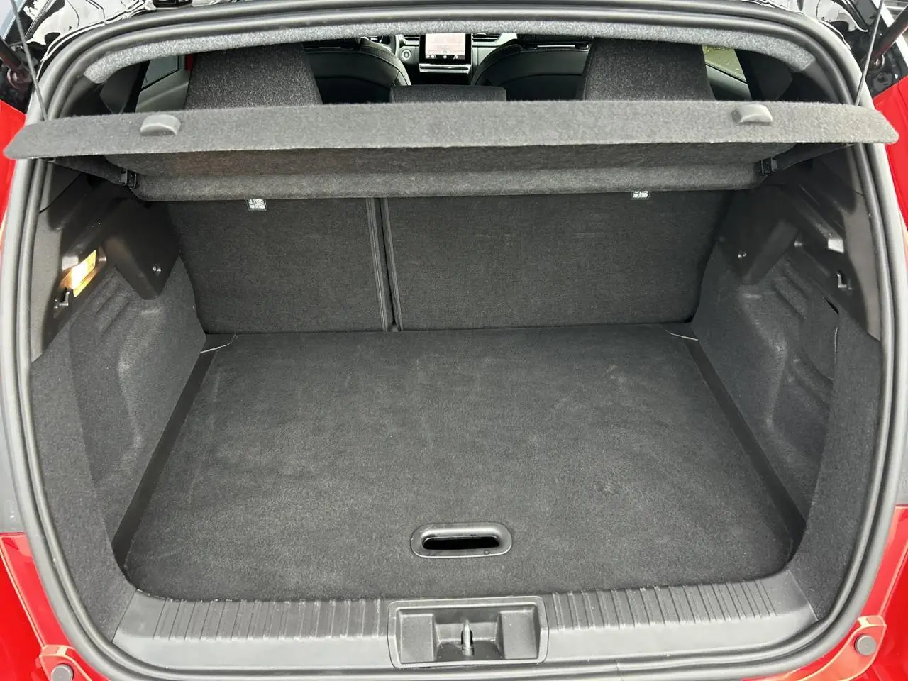 Coffre ouvert vu de l'arrière du Renault Captur Rouge Flamme avec intérieur noir et plancher plat.