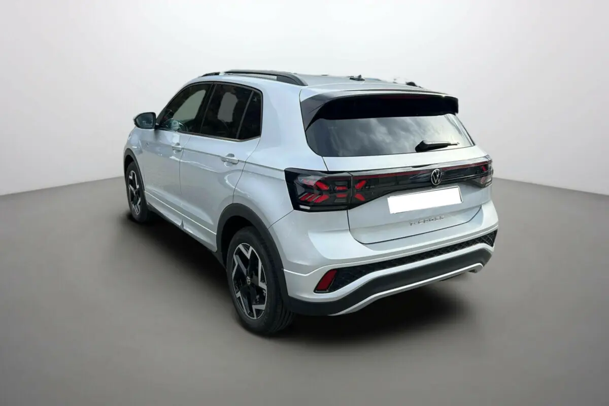 Volkswagen T-Cross TSI 116 DSG7 R-Line gris argent vu en 3/4 arrière droit avec jantes alu 17 pouces et vitres surteintées.