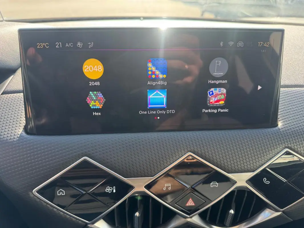 Vue rapprochée de l’écran tactile et des commandes en losange du tableau de bord du DS3 gris 2024.