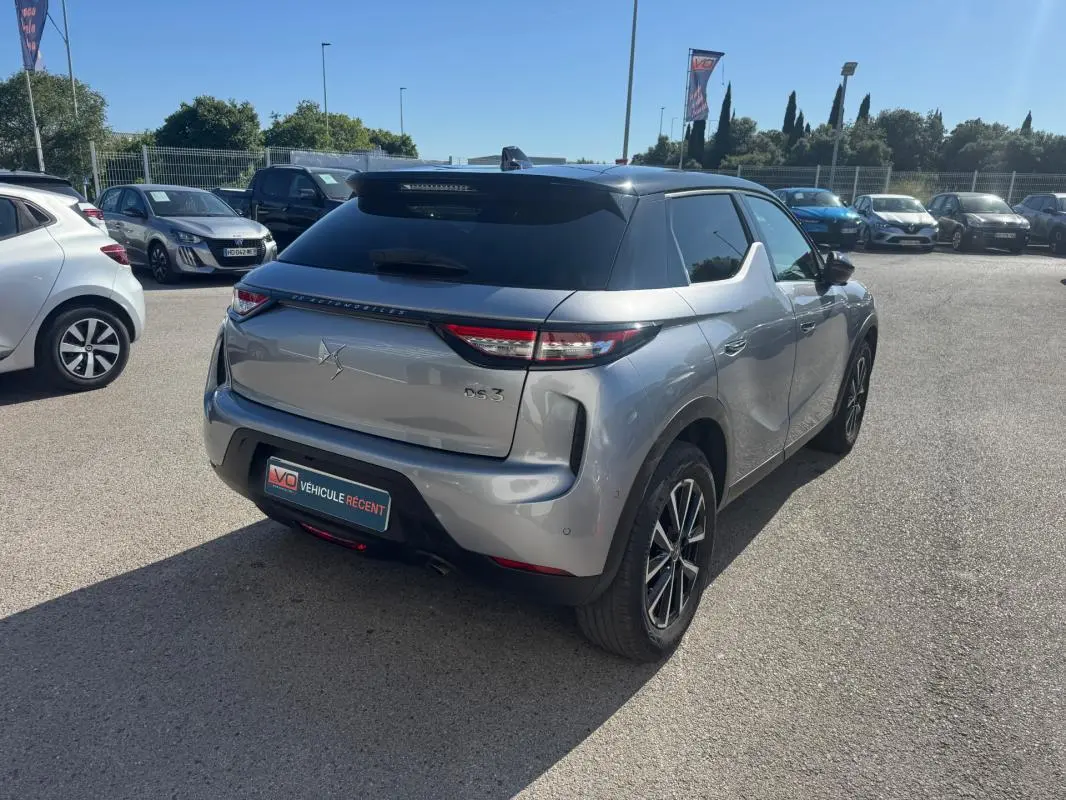 Vue 3/4 arrière droite d'une DS3 100 BVM6 Bastille gris avec jantes alliage 18 pouces et toit noir brillant.