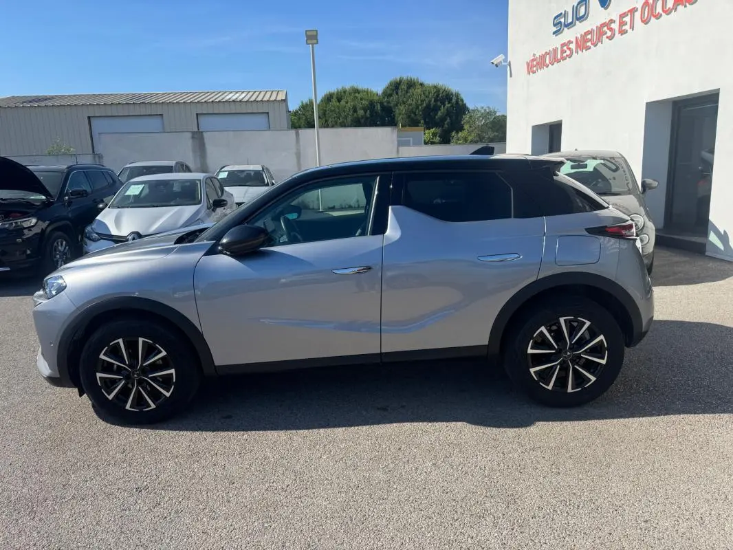Vue de profil côté gauche d'une DS3 100 BVM6 Bastille gris 2024 avec jantes alliage 18 pouces sur parking extérieur.