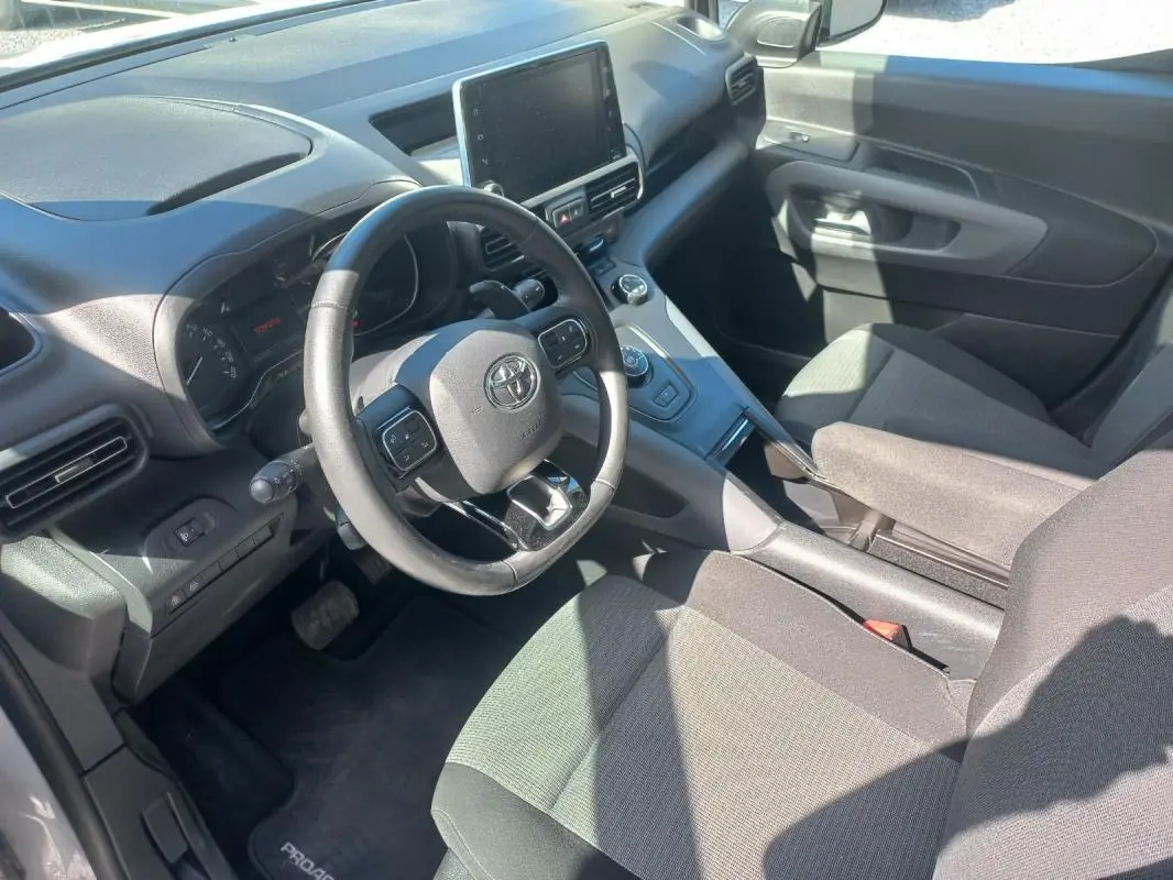 Vue intérieure côté conducteur du Toyota Proace City Verso gris 2023, avec volant multifonction et écran tactile central.