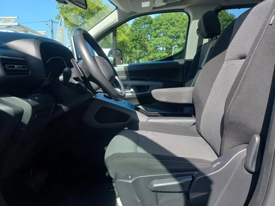 Intérieur côté conducteur du Toyota Proace City Verso gris 2023, vue sur sièges et volant avec boîte manuelle.