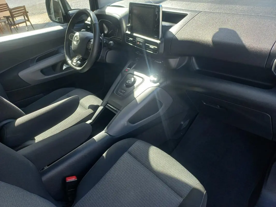 Vue intérieure côté conducteur du Toyota Proace City Verso gris 2023, avec tableau de bord moderne et écran tactile central.