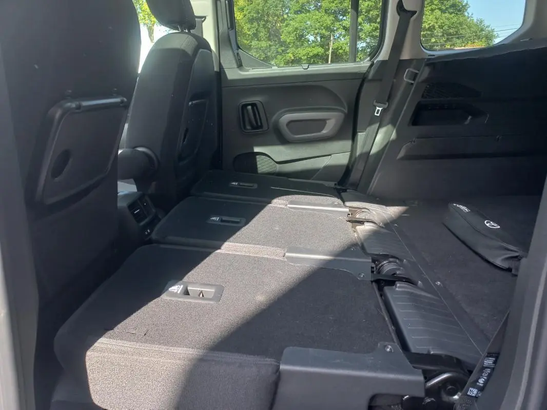 Vue intérieure arrière du Toyota Proace City Verso gris 2023, sièges rabattus pour agrandir le coffre.