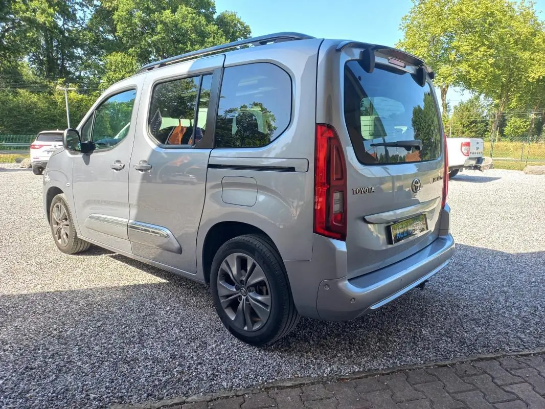 Vue 3/4 arrière droite d'un Toyota Proace City Verso gris 2023, version Medium Executive avec vitres teintées et jantes alliage.