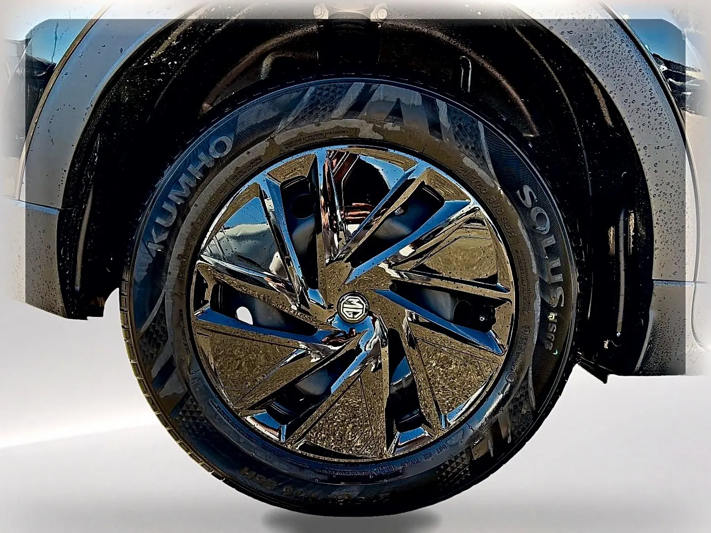 Gros plan sur la roue avant droite noire du MG ZS 1.5 hybrid 197 avec jante brillante et logo MG au centre.