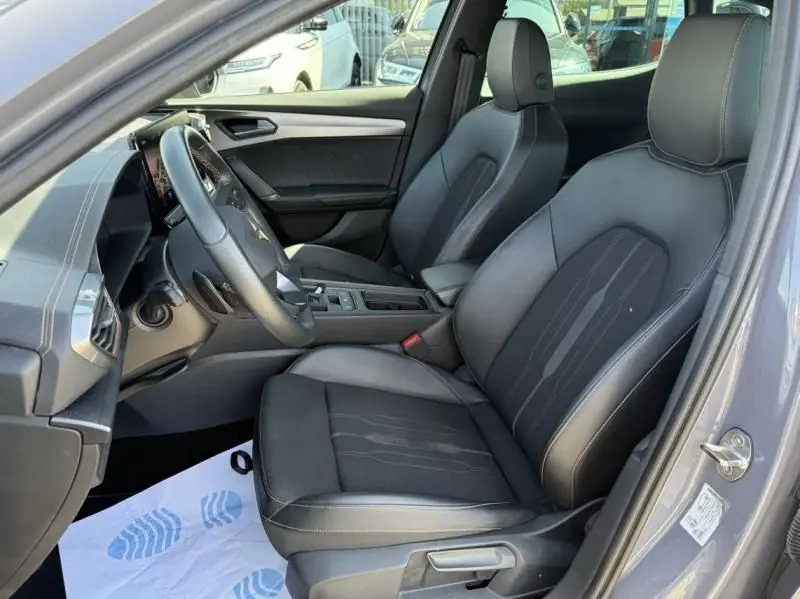 Vue intérieure côté conducteur du CUPRA Formentor gris 2023, avec sièges en cuir noir et tableau de bord moderne.