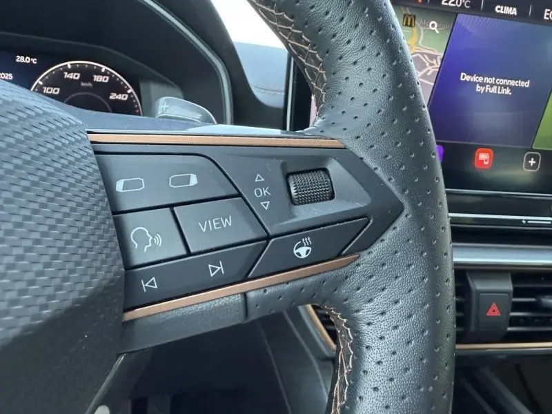 Gros plan sur les commandes du volant en cuir perforé du CUPRA Formentor gris 2023, avec affichage digital en arrière-plan.